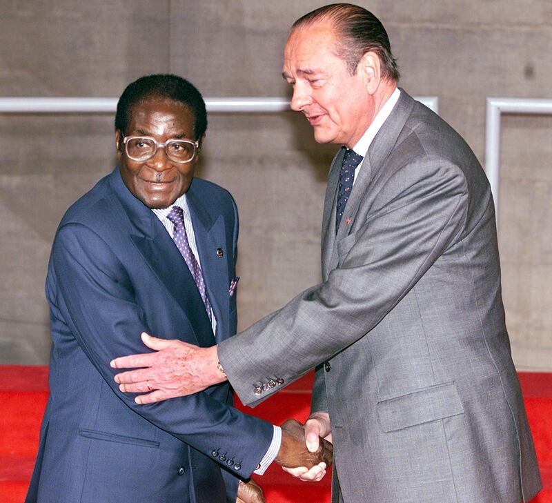 (FILES) In this file photo taken on November 27, 1998 French President Jacques Chirac (R) greets his Zimbabwean counterpart Robert Mugabe at the opening of the 20th Franco-African summit in Paris. - Former French President Jacques Chirac has died at the age of 86, it was announced on September 26, 2019. (Photo by Pascal GUYOT / AFP)