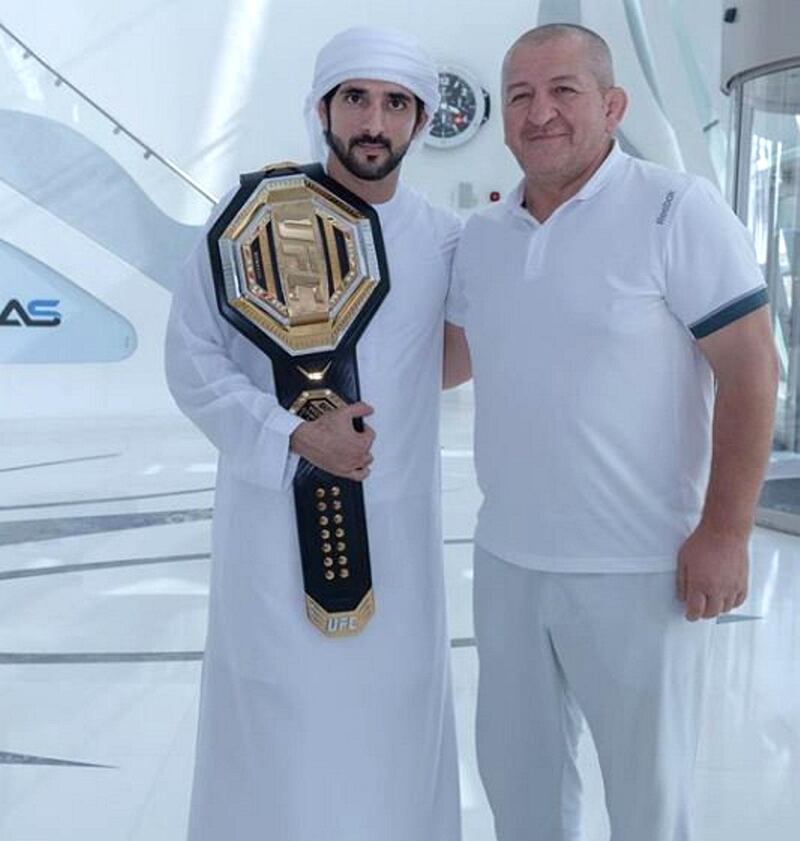 Sheikh Hamdan holding the UFC Championship belt alongside Abdulmanap, father Khabib.