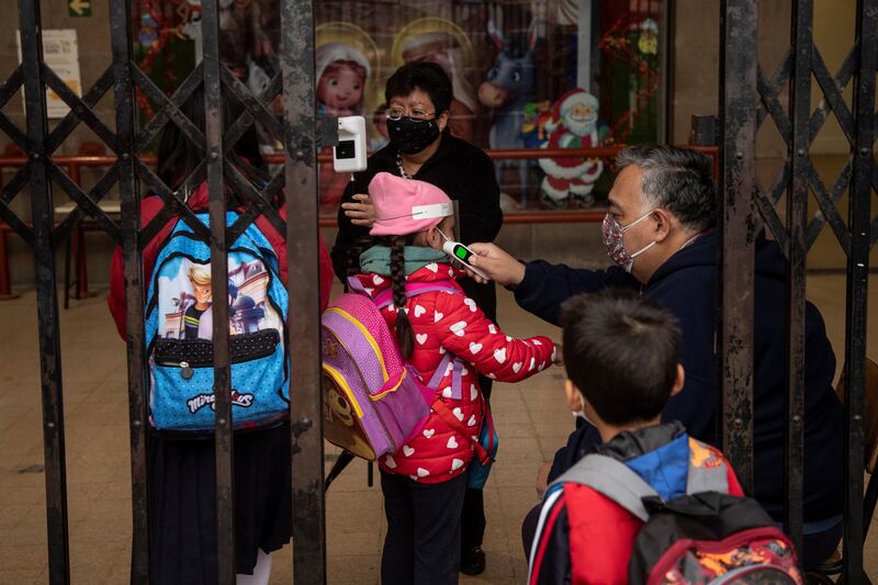 A teacher takes a pupil's temperature as face-to-face classes return in Mexico City. EPA