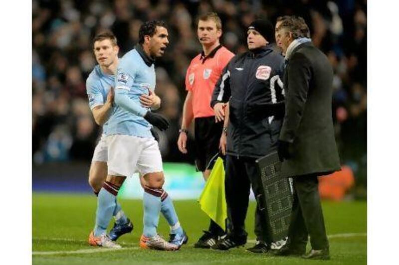 Carlos Tevez exchanges words with Roberto Mancini after being substituted this month.