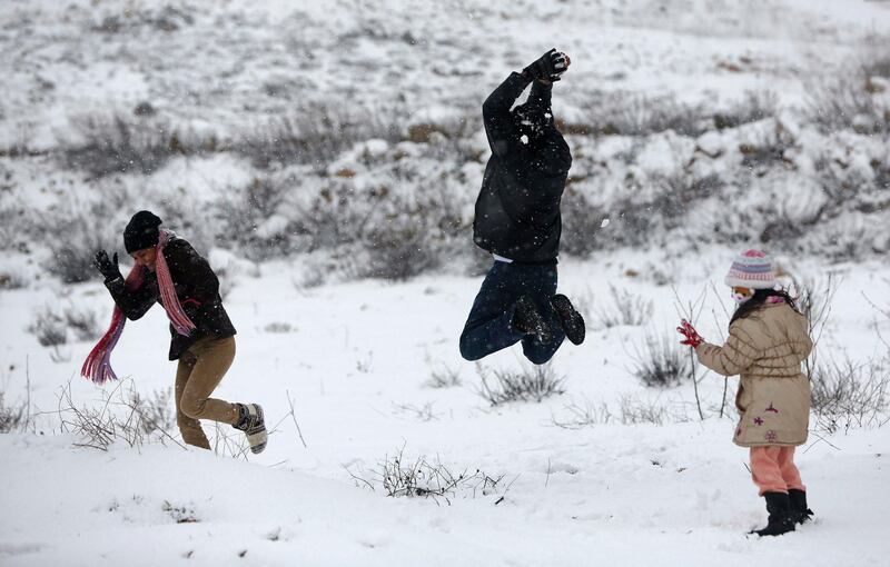 Palestinians play in the snow in the West Bank city of Ramallah January 10, 2013. At least 17 people have died due to a storm in Lebanon, Jordan, Turkey, Israel and the Palestinian territories. Meteorological agencies in Israel and Lebanon both called it the worst storm in 20 years. REUTERS/Mohamad Torokman (WEST BANK - Tags: ENVIRONMENT)