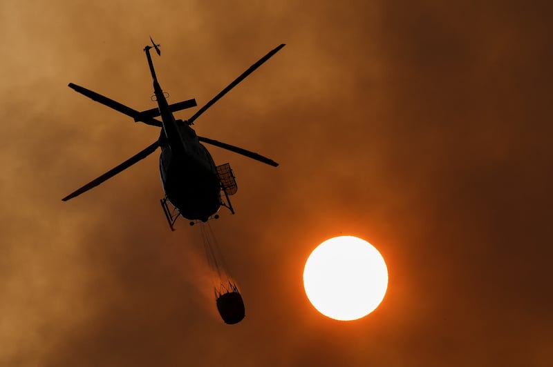A helicopter works to extinguish a wildfire, in the area of Pico de las Nieves, on the Canary Island of Gran Canaria, Spain. Reuters