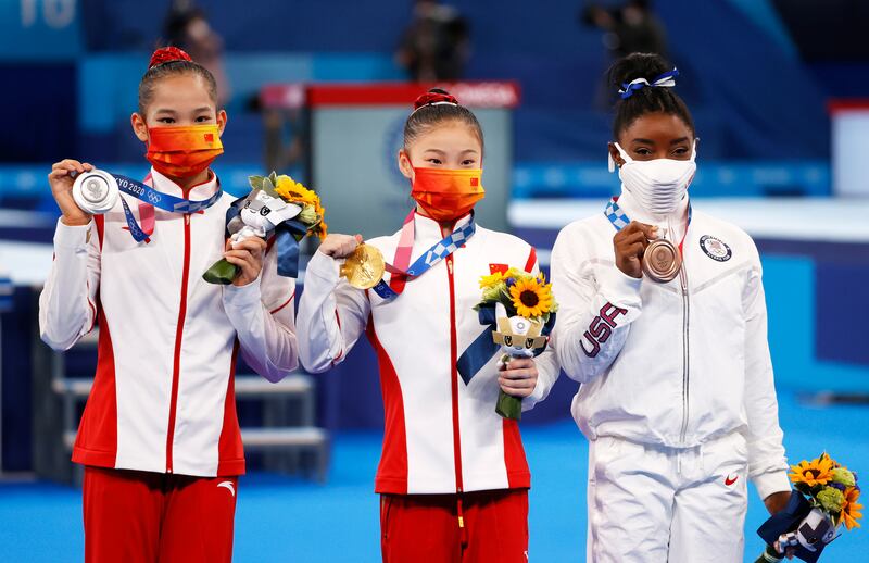 Silver medalist Tang Xijing of China, gold medalist Guan Chenchen of China and bronze medalist Simone Biles of USA pose on the podium.
