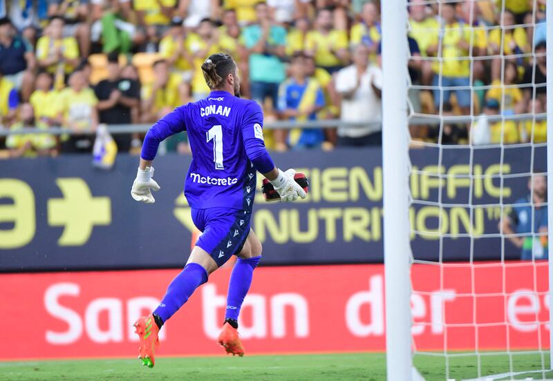 Cadiz goalkeeper Jeremias Ledesma runs towards the stands holding medical gear. AFP