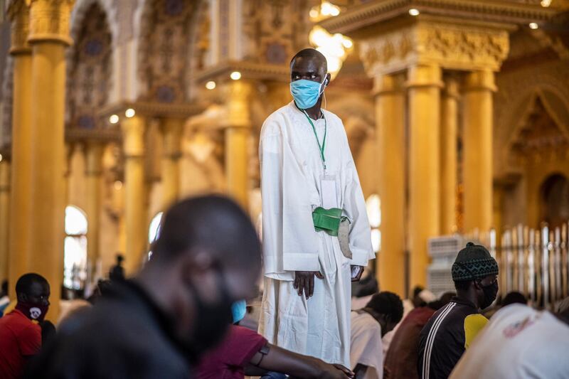 A follower of the Senegalese Mouride brotherhood, an order of Sufi Islam, wears a mask during Muslim Friday prayers at West Africa's largest mosque the Massalikul Jinaan, in Dakar, Senegal. AP Photo