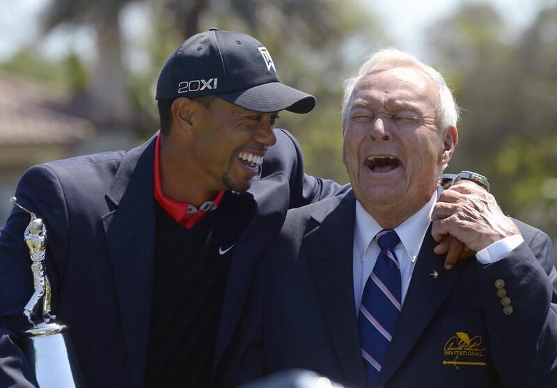 Tiger Woods, left, and Arnold Palmer share a laugh during the trophy presentation after Woods won the Arnold Palmer Invitational golf tournament in Orlando, Florida on March 25, 2013. Because of a bad back, Woods will not be able to defend his title this weekend. AP Photo/Phelan M. Ebenhack