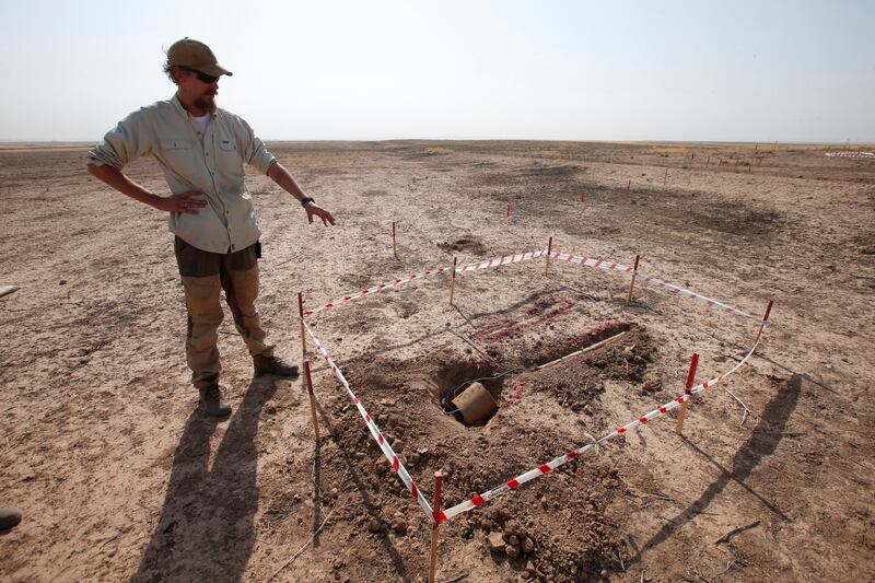 A member of Norwegian People's Aid with a landmine found east of Mosul, Iraq.  Reuters