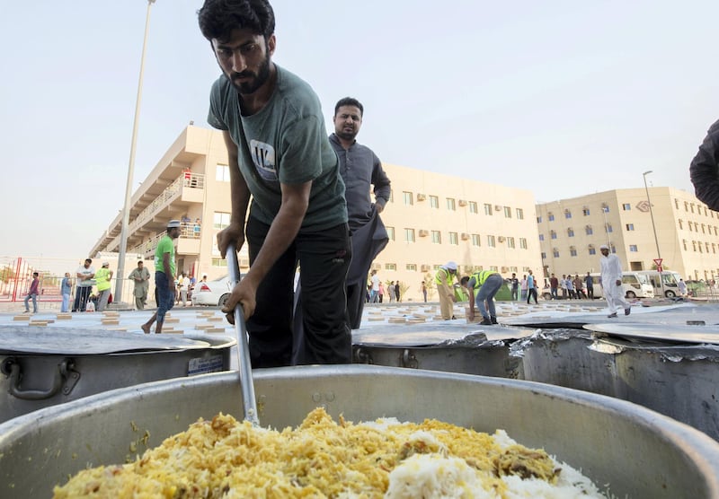 DUBAI, UNITED ARAB EMIRATES -  A volunteer mixing a biryani pot to be served to the workers.  Dubai Police join hands with Berkeley Assets to serve up Iftar dinner to mark Laylatul Qadr for 10,000 labourers with seating for 5,000 and another 5,000 laborers will go home with meal boxes in Al Muhaisnah, Dubai.  Ruel Pableo for The National