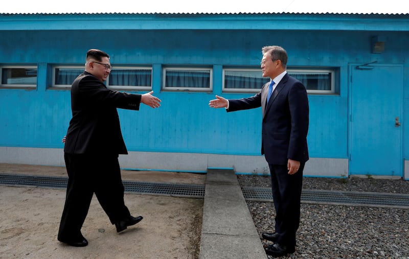 FILE PHOTO: South Korean President Moon Jae-in and North Korean leader Kim Jong Un (L) are about to shake hands on their first ever meeting at the truce village of Panmunjom inside the demilitarized zone separating the two Koreas, South Korea, April 27, 2018.  Korea Summit Press Pool via Reuters/File Photo