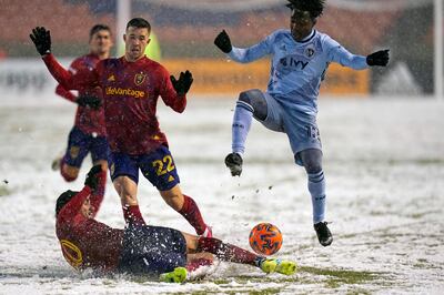 Real Salt Lake defender Marcelo Silva (30) slides to clear the ball against Sporting Kansas City forward Gerso (12) in the first half of an MLS soccer match, as Real Salt Lake defender Aaron Herrera (22) comes in on the play, Sunday, Nov. 8, 2020, in Sandy, Utah. (AP Photo/Rick Bowmer)