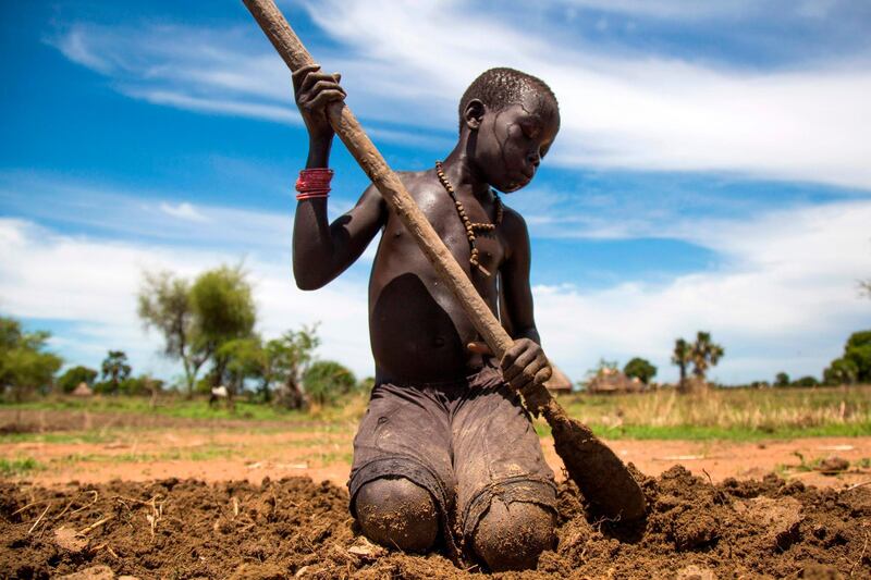 (FILES) In this file photo Nyibol Lual, 13 years old, helps her family to prepare the land for cultivation on May 31, 2017, in Panthau, Northern Bahr al Ghazal, South Sudan.  The International Monetary Fund and World Bank on March 25, 2020 called for governments to put a hold on debt payments from the world's poorest nations so they can battle the coronavirus pandemic. "The World Bank Group and the IMF believe it is imperative at this moment to provide a global sense of relief for developing countries as well as a strong signal to financial markets," the Washington-based development lenders said in a joint statement. / AFP / Albert Gonzalez Farran

