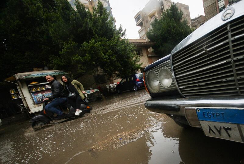 A couple ride a scooter during a thunderstorm and heavy rains in downtown Cairo. Reuters
