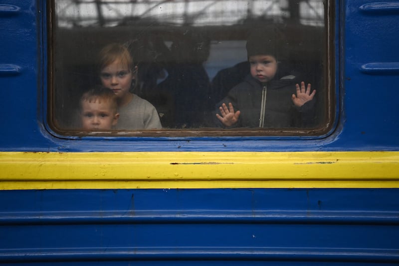 Children look out from a carriage window as a train prepares to depart from a station in Lviv to the town of Uzhhorod near the border with Slovakia. AFP