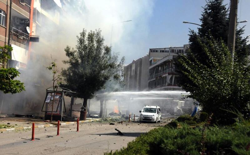 Firefighters work to extinguish a fire after a car bomb attack in the city center of Van. DHA via AP