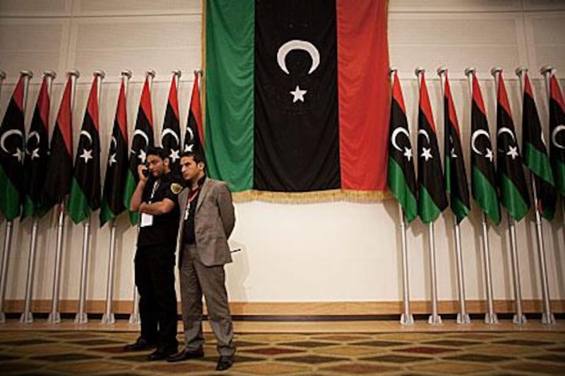 Security members at the Libyan election result conference. Results show a secular, liberal alliance in first place in the nation's first free vote, but they need to woo independent candidates.