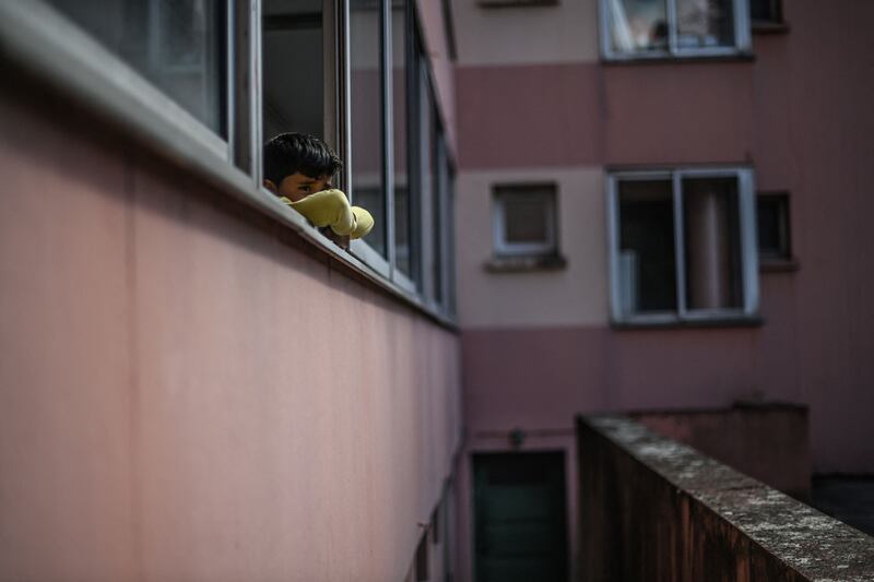 A boy looks out of a window near Lyon, France, as Afghan refugee families arrived after their evacuation from Kabul. AFP