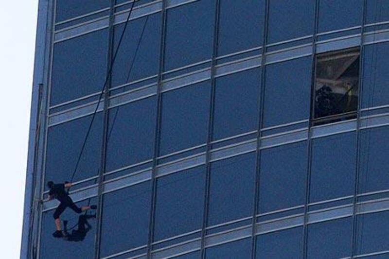 DUBAI, UNITED ARAB EMIRATES – Nov 5: Crew member of Mission: Impossible Ghost Protocol during the shooting at Burj Khalifa in Dubai. Tom Cruise doing the stunts on the left side in black dress (not sure about that pl.check with reporter). (Pawan Singh / The National) For News. Story by Eugene

