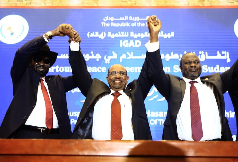 (FILES) In this file photo taken on June 27, 2018 Sudanese President Omar al-Bashir (C) raises held hands with South Sudan's President Salva Kiir Mayardit (L) and South Sudanese rebel leader Riek Machar (R) after the two South Sudanese arch-foes agreed in Khartoum on June 27, 2018, to a "permanent" ceasefire to take effect within 72 hours in their country. Sudanese leader Omar al-Bashir, long wanted on genocide and war crimes charges, was finally brought down on April 11, 2019 in a popular uprising by the very people he ruled with an iron fist for 30 years. One of Africa's longest-serving presidents, the 75-year-old had remained defiant in the face of months-long protests that left dozens of demonstrators dead in clashes with security forces. / AFP / ASHRAF SHAZLY
