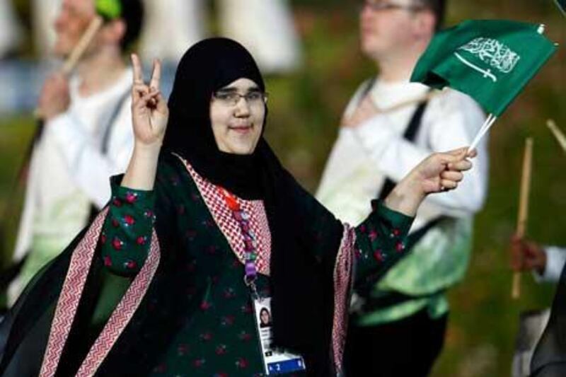 Saudi Arabia's Wojdan Ali Seraj Abdulrahim Shaherkani gestures as she walks with the contingent in the atheletes parade during the opening ceremony of the London 2012 Olympic Games.