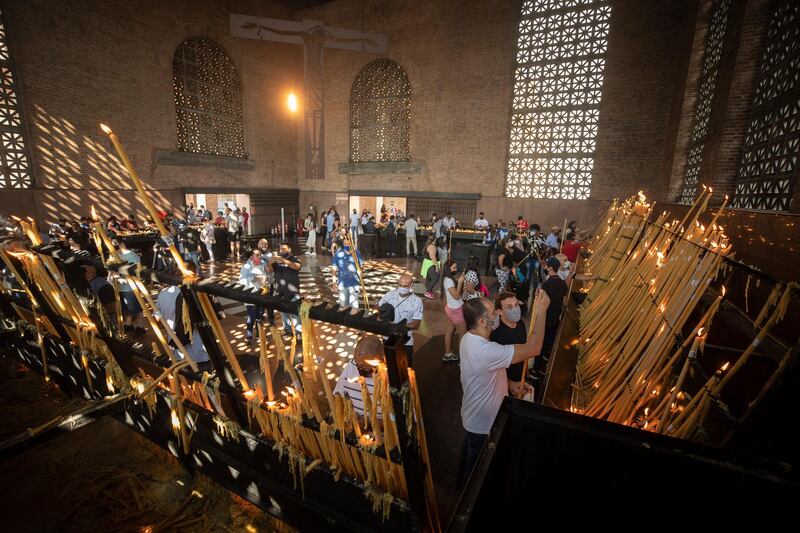 People light candles inside the candle room of Our Lady of Aparecida Basilica, the temple of Brazil’s patron saint on her feast day in Aparecida, Brazil. Two of Brazil’s biggest Catholic celebrations scheduled for this holiday weekend were downscaled and cancelled, yet people still appeared, underscoring the challenge of extolling Covid-19 precautions as well as pressures to ease up. AP Photo