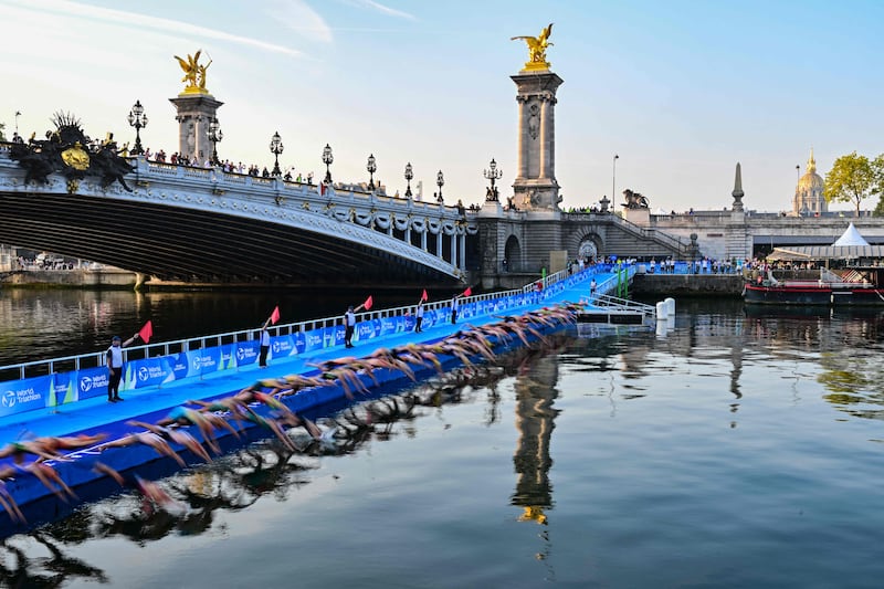 Triathletes dive into the Seine river next to the Pont Alexandre III during a test event for the Paris Olympics. AFP