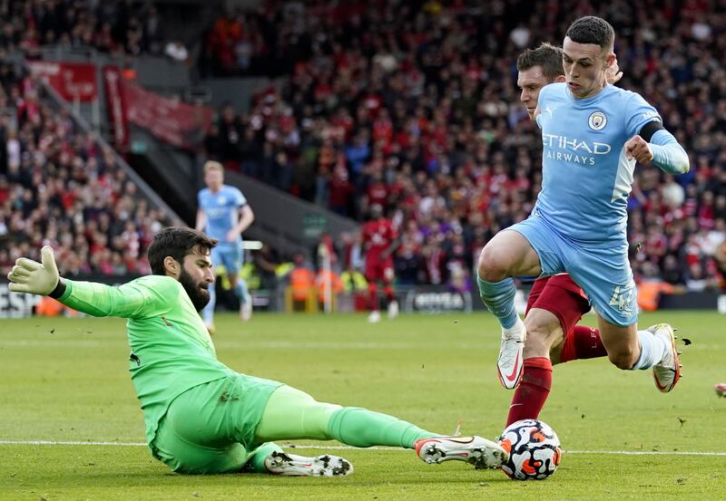 Phil Foden of Manchester City attempts to skip past Liverpool goalkeeper Alisson Becker. AFP