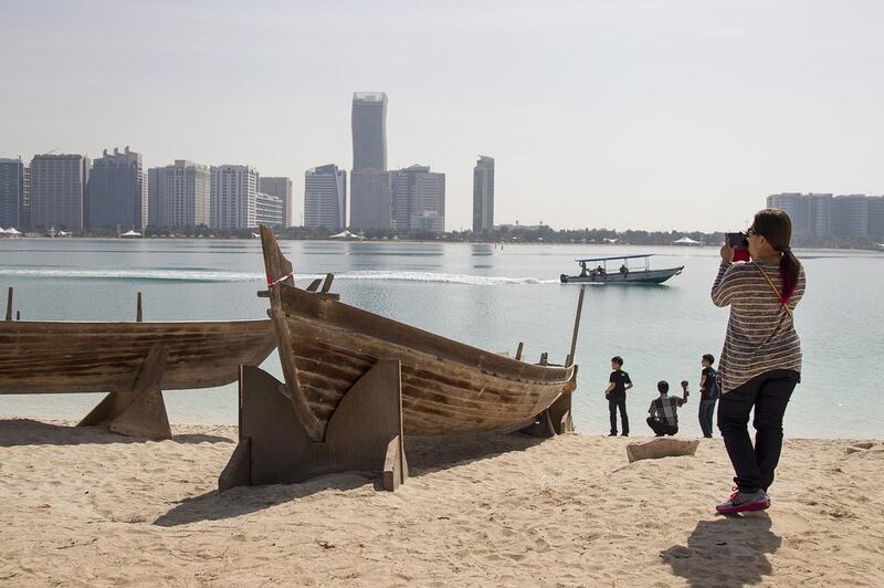 A tourist takes photos at Heritage Village in Abu Dhabi. Mona Al Marzooqi / The National