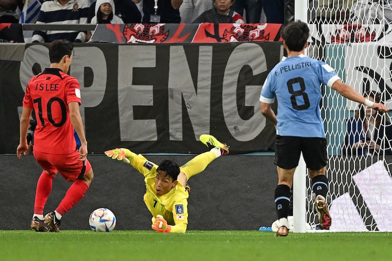South Korea's goalkeeper Kim Seung-gyu dives to secure the ball. AFP