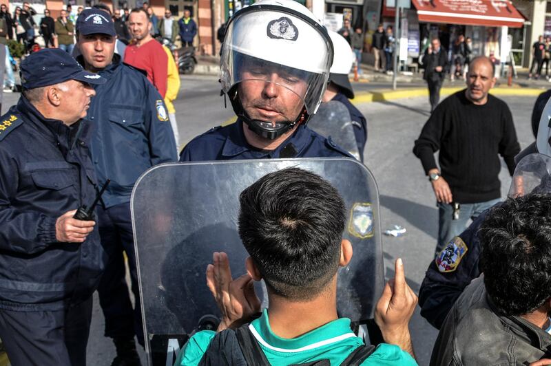 A migrant speaks to a Greek policeman during minor clashes at the port of Mytilene after locals block access to the Moria refugee camp, on the northeastern Aegean island of Lesbos, Greece. AP Photo