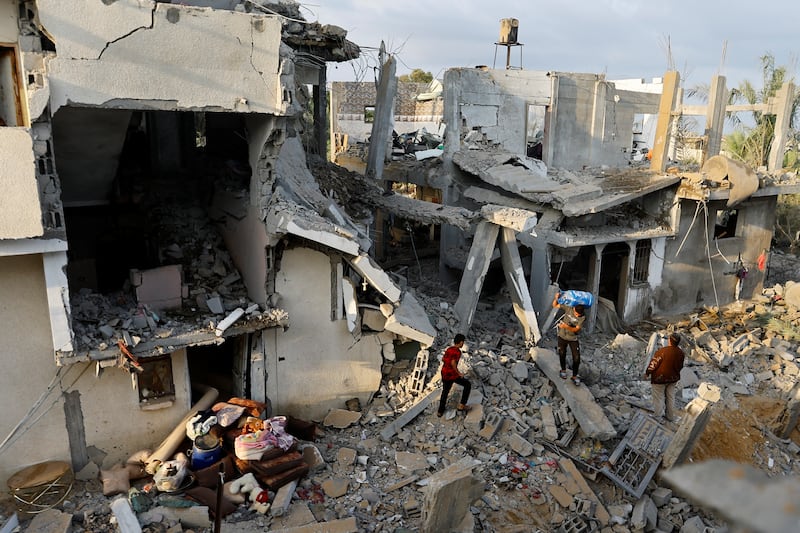 Palestinians carry belongings near their damaged house following Israeli strikes in Khan Younis, in southern Gaza, on Wednesday. Reuters