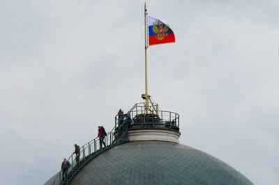 People on the dome of the Senate Palace, one of the main buildings within the Kremlin compound in central Moscow. AFP