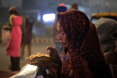 A woman eats while she settles down for the night outside the hospital. Taniya Dutta / The National