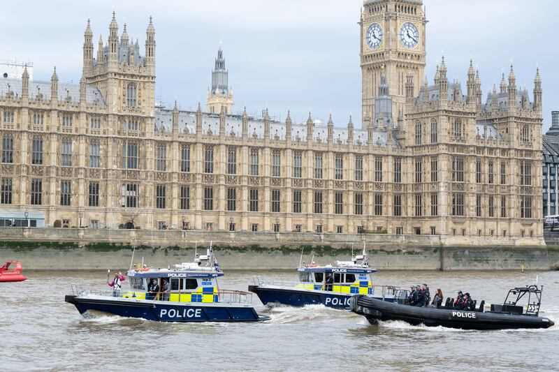 Batonbearer-Anthony Okereafor carries the baton on a Marine Police boat on the River Thames, in London. Getty Images