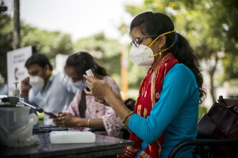 A health worker prepares a dose of coronavirus vaccine at a drive-through centre set up at the CyberHub open marketplace in Gurgaon, Haryana, northern India. Bloomberg