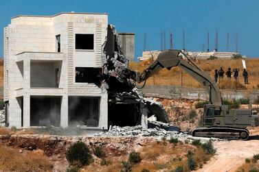 Israeli security forces tearing down one of the Palestinian buildings still under construction which have been issued notices to be demolished in the West Bank village of Dar Salah, on July 22, 2019. AFP