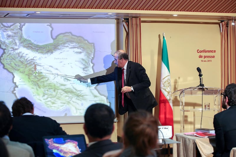 Mehdi Abrichamtchi (C), Peace and Security Committee Chairman of the National Council of Resistance of Iran (NCRI) shows to journalists a secret nuclear site in Iran during a press conference on November 18, 2013 in Paris. Iran and six world powers meet in Geneva from November 20 for the third time since the election of President Hassan Rouhani to try to end the decade-old standoff over Tehran's nuclear programme.  AFP PHOTO / Marion Ruszniewski (Photo by Marion Ruszniewski / AFP)