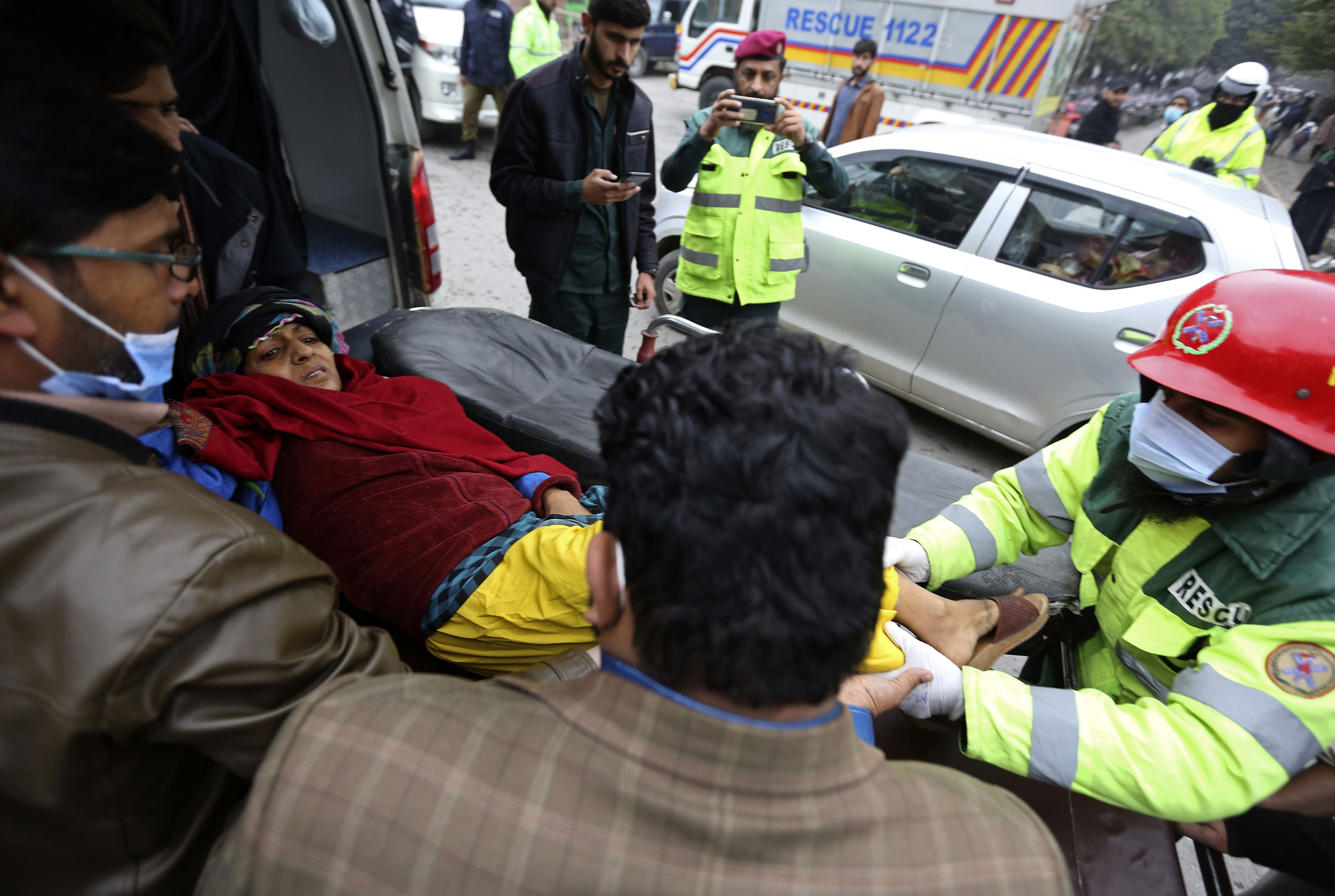 Rescue workers remove an injured woman from the site of the explosion. AP