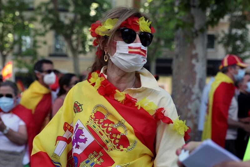 A demonstrator wearing a Spanish national flag attends the rally. EPA