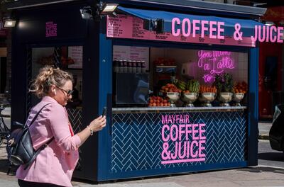 A pedestrian passes a coffee and juice stall on Oxford Street in London. Bloomberg
