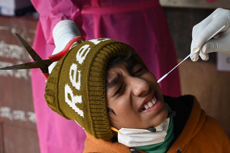 A health worker collects a swab sample from a child to test for Covid-19 at a hospital in Kolkata. AFP