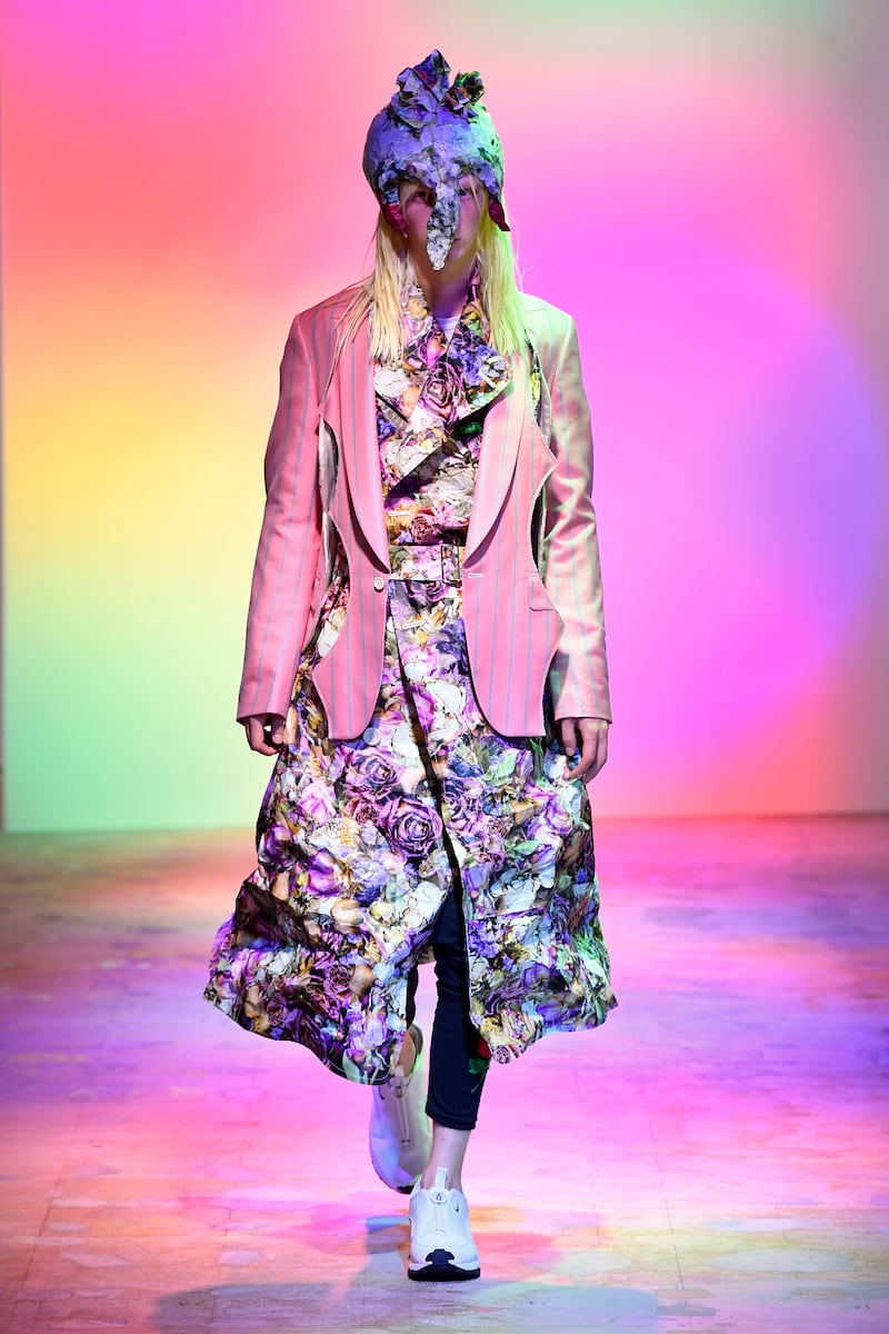 A silk jacket is cut away, and worn over a floral trench coat at Comme des Garcons, for spring / summer 2022. Courtesy Comme des Garcons