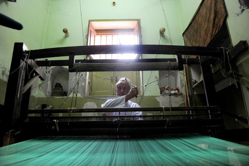 Indian weaver Sardar Haji Hafizullah works on a sari, the traditional dress worn by Indian women, at a handloom factory in Rajapura Varanasi. Sanjay Kanojia / AFP