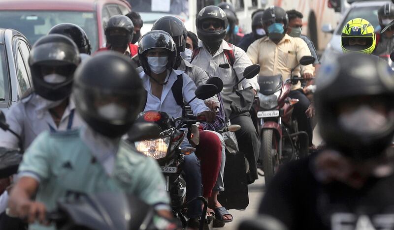 Motorists ride through a busy street in Mumbai. AP Photo
