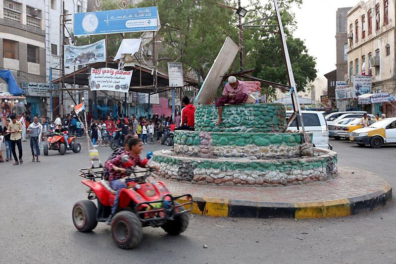 Two Yemeni youths drive a quad bike as people celebrate the Eid Al-Adha in Aden .  AFP
