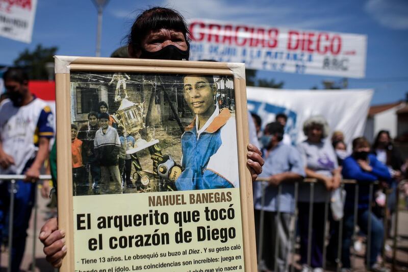 A woman holds a placard with a news article about Maradona at Villa Palito neigbourhood in La Matanza municipality, Buenos Aires province. EPA