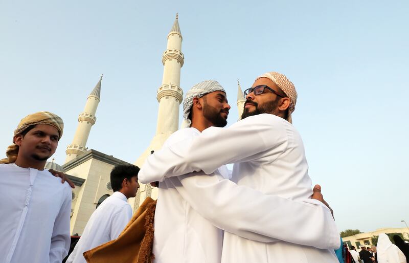 People exchange greetings after prayers at Al Farooq Omar Bin Al Khattab Mosque. Pawan Singh / The National