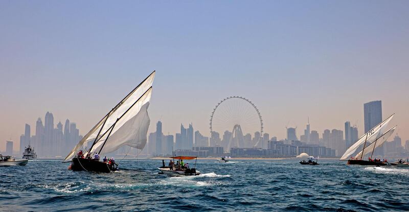 Dhows race towards the finish line of the Al Gaffal, with the Dubai Eye in the background. AFP