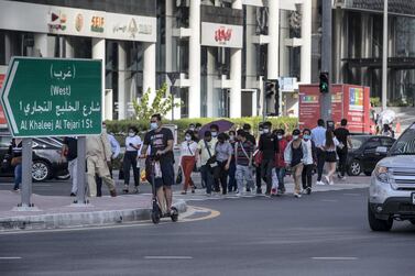 Pedestrians wearing face masks cross the busy intersection of Al Khaleej Al Tejari street and Mustaqbal street in Business Bay, Dubai. Antonie Robertson / The National