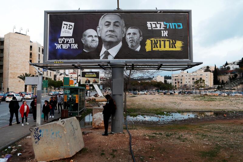 A Blue and White party election campaign banner depicting Israeli Prime Minister Benjamin Netanyahu, Justice Minister Amir Ohana and Education Minister Rafi Peretz with Hebrew writing reading: "Blue and White or Erdogan" and "Saving Israel", is seen in Modiin, Israel. REUTERS