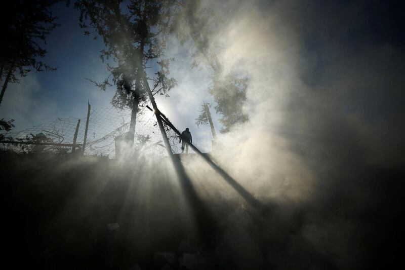 Smoke is seen as a Palestinian man inspects a militant target that was hit in an Israeli airstrike in the northern Gaza Strip. Mohammed Salem / Reuters.